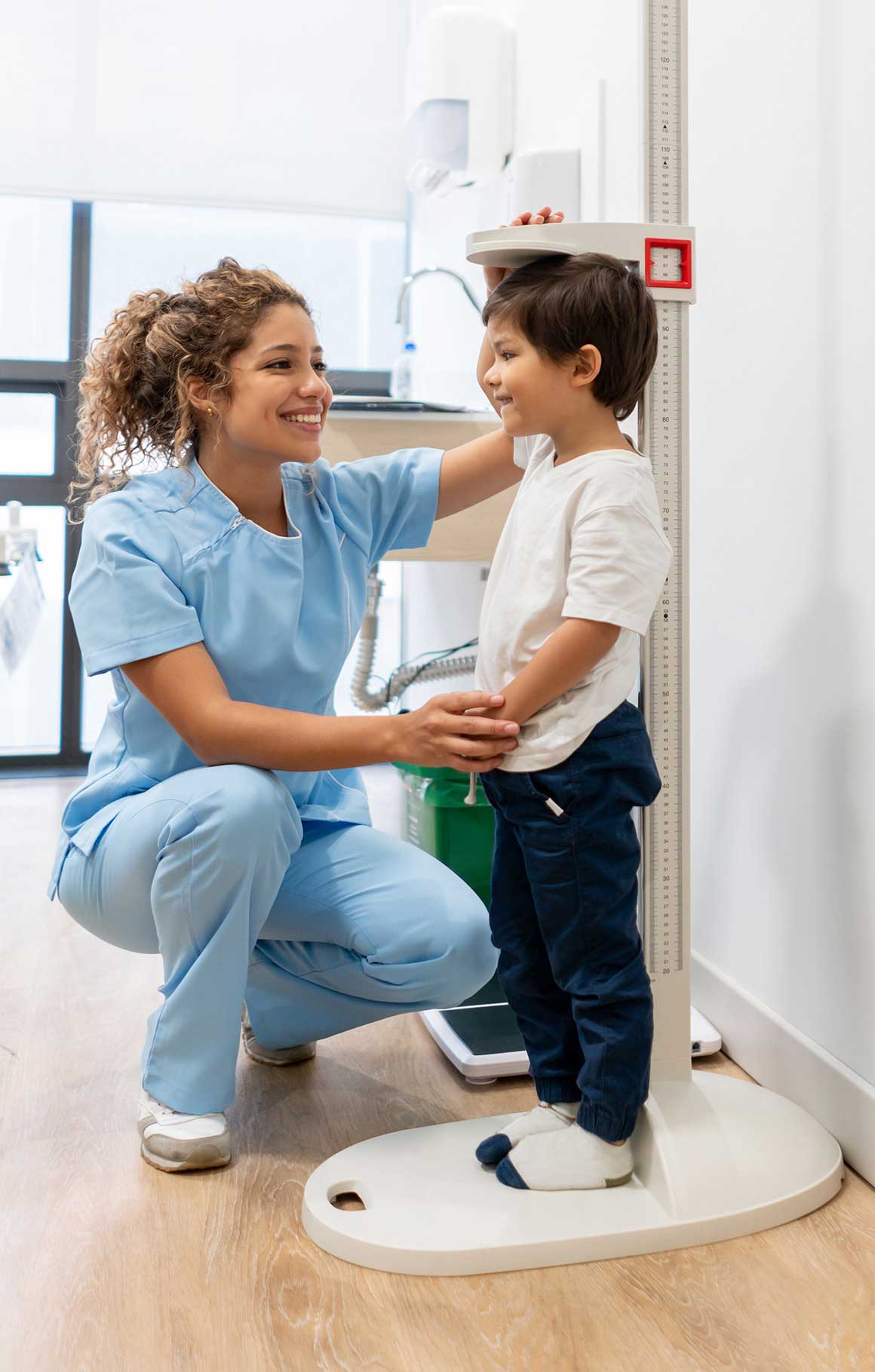 Nurse measuring young girl's height